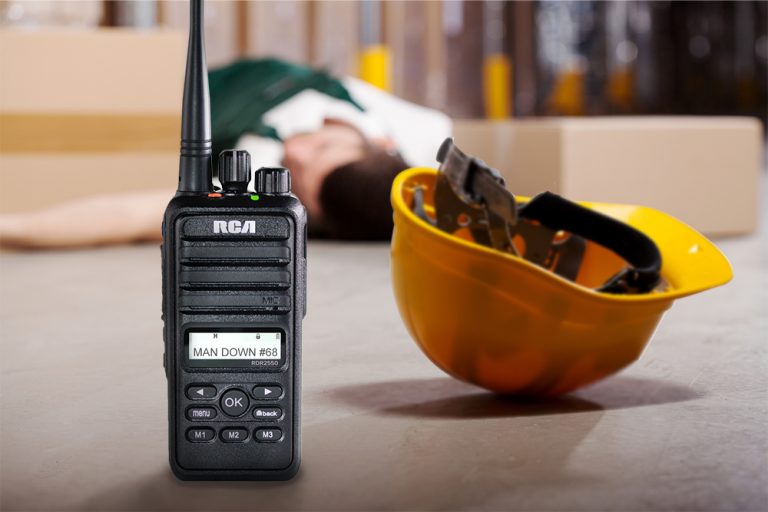 A worker lies unconscious on the ground. A two-way radio displays the triggered alert, "Man Down."