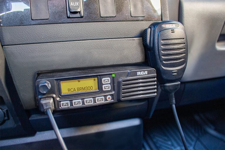 An RCA BRM300D mobile two-way radio is mounted to a vehicle's center console.
